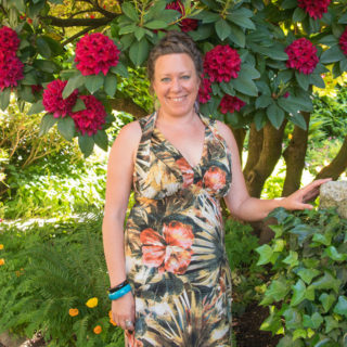 Photo of Alyssa with hair up in a floral dress outside